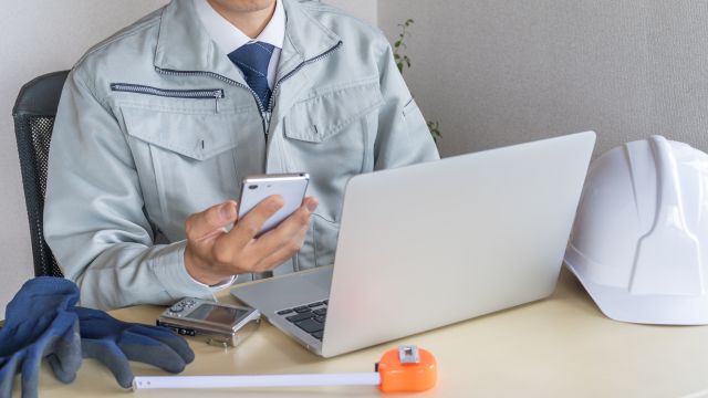PCや携帯を触る建設業者