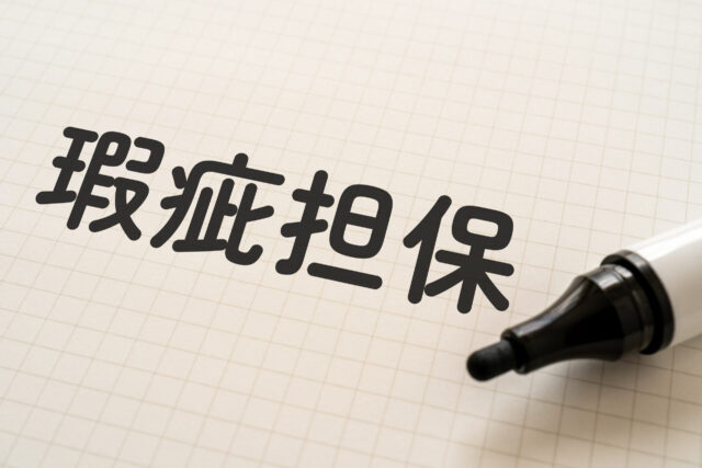 瑕疵担保と書かれたノートとマーカー